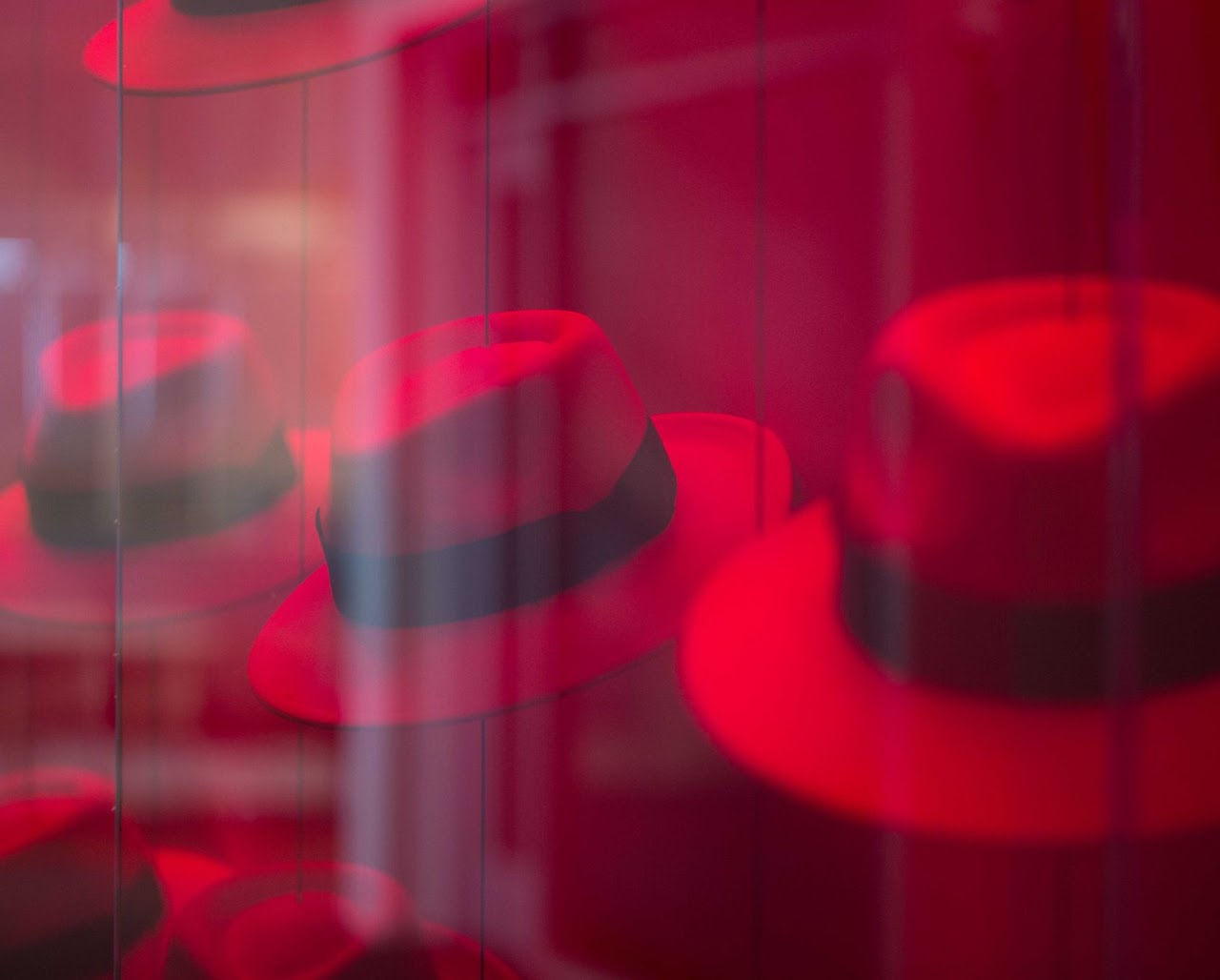A wall of red hats behind glass