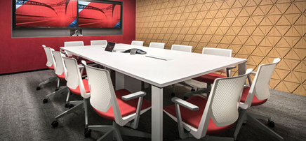 Conference room with red accents and large screen.