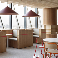 Bright and airy office pantry with light wood tables, chairs, and natural light from windows