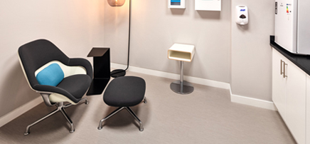 Modern office safety room with first aid kits, chair, and soft lighting.