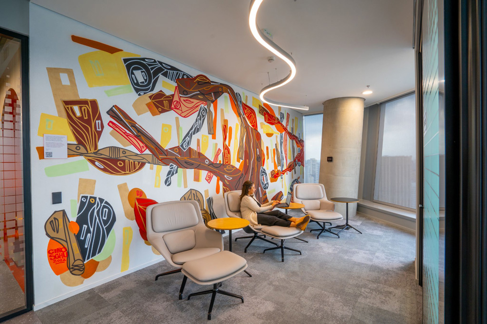 a casual working space with a abstract brightly colored mural covering one wall
