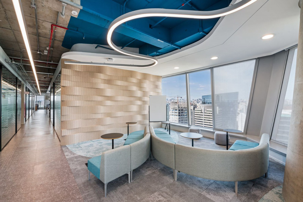 a relaxed break area featuring curved sofas facing a glass window wall