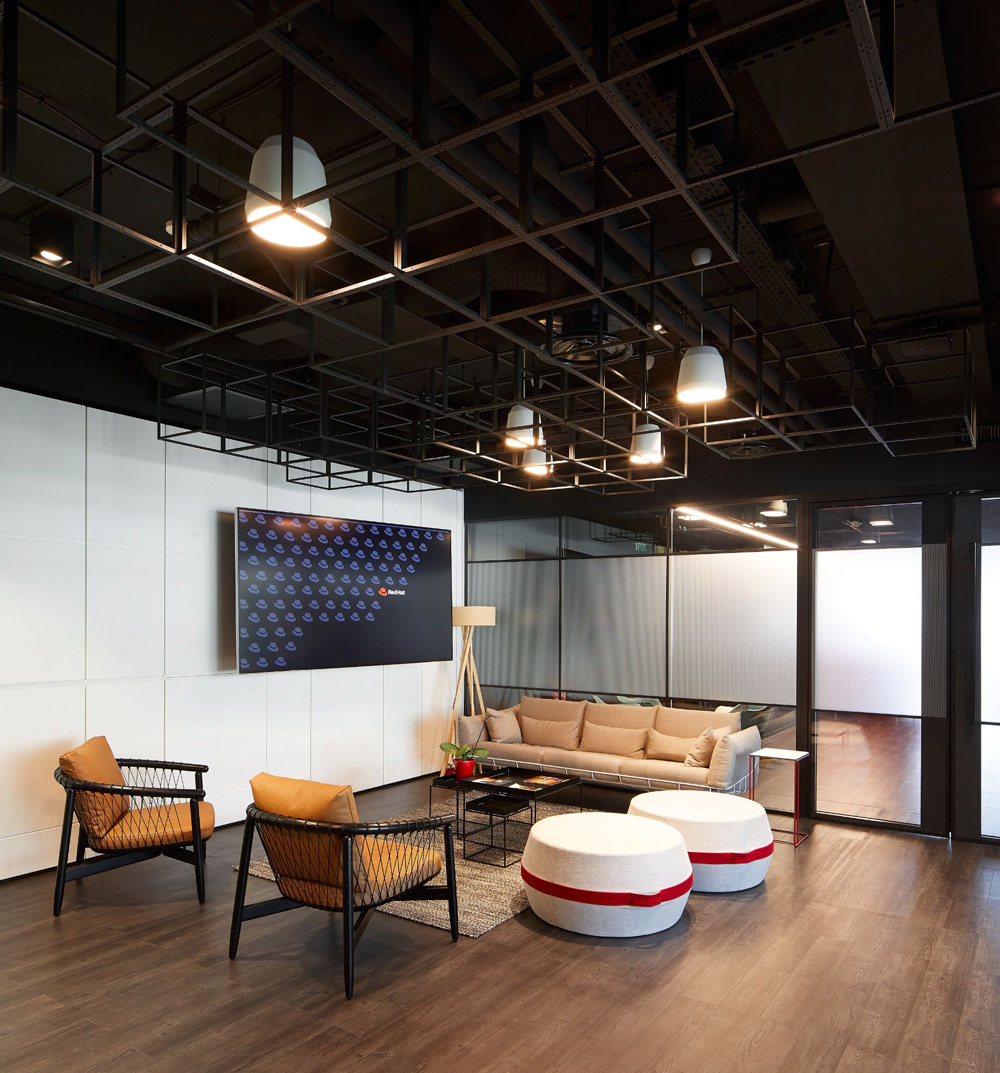 a common area with wood flooring, exposed rafters, and brown and khaki furniture