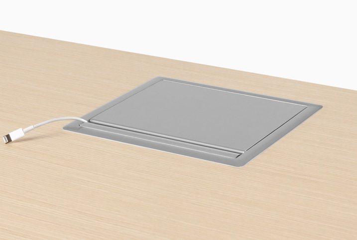 Closed desk outlet panel, with a cord hanging out