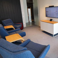 Lounge area with blue chairs and a media console.