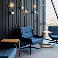 Stylish lounge with dark textured wall and blue armchairs.