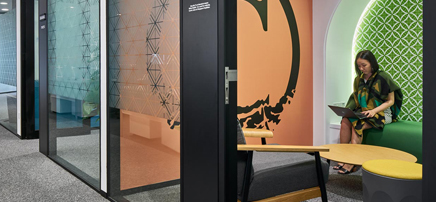 Office collaboration space with frosted glass and seating.