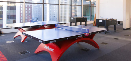 Large game room with a pool table and big windows.