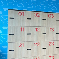 Wall of office lockers with alternating light wood and blue patterned, numbered doors