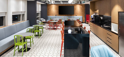 Dark-themed office pantry featuring wooden surfaces, warm pendant lighting, and bar-style seating