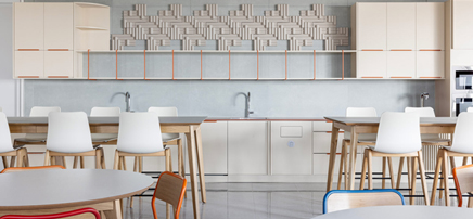 Large, bright office pantry filled with multiple light wood dining tables and chairs, with large windows