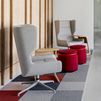Office hallway with red stools, wooden wall paneling, and glass-walled rooms