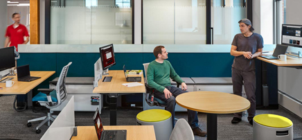 Bright, collaborative office space with wooden desks and yellow stools